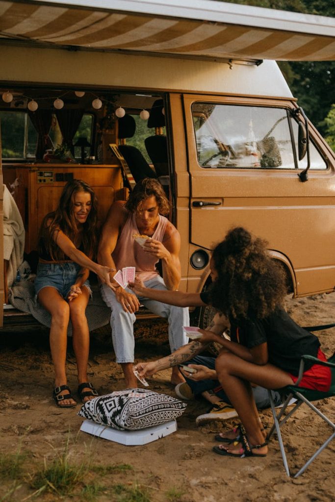 Friends Playing Cards by a Campervan reizen met een camper