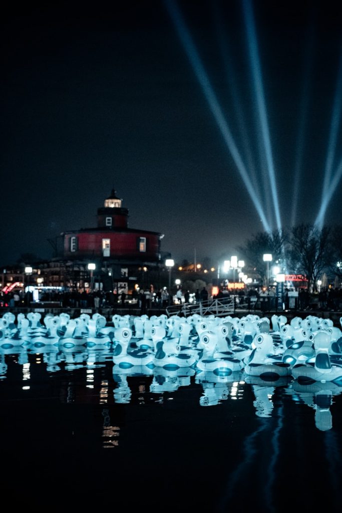 people in white shirt and black pants standing on ice field during night time de mooiste steden van japan sapporo